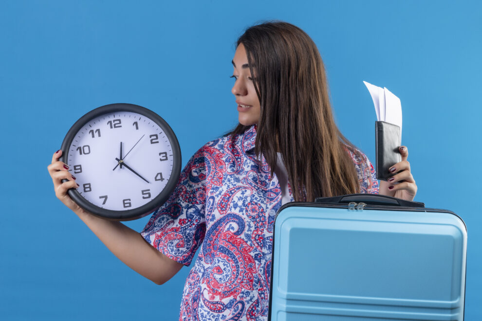 young beautiful traveler woman holding blue suitcase with ticket tickets